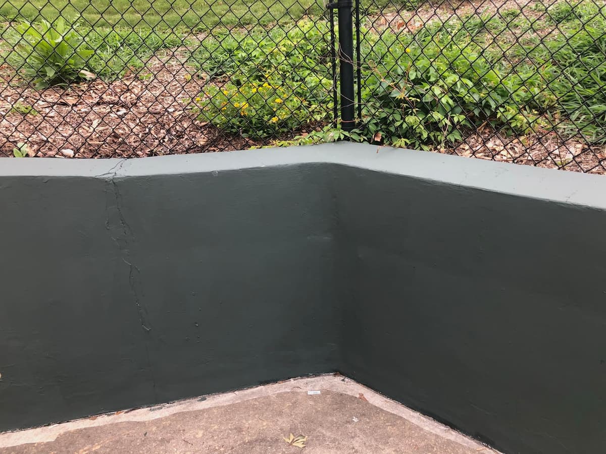 The nine-foot green wall at the entrance gate and extending on down the third base line has been repainted