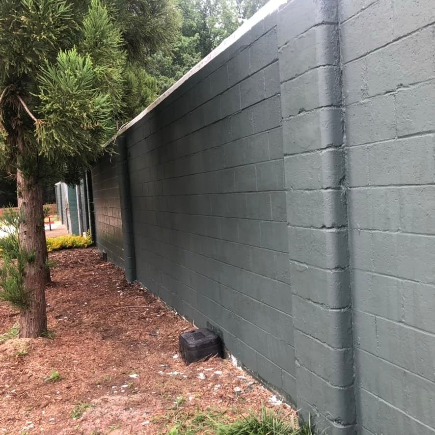 The nine-foot green wall at the entrance gate and extending on down the third base line has been repainted